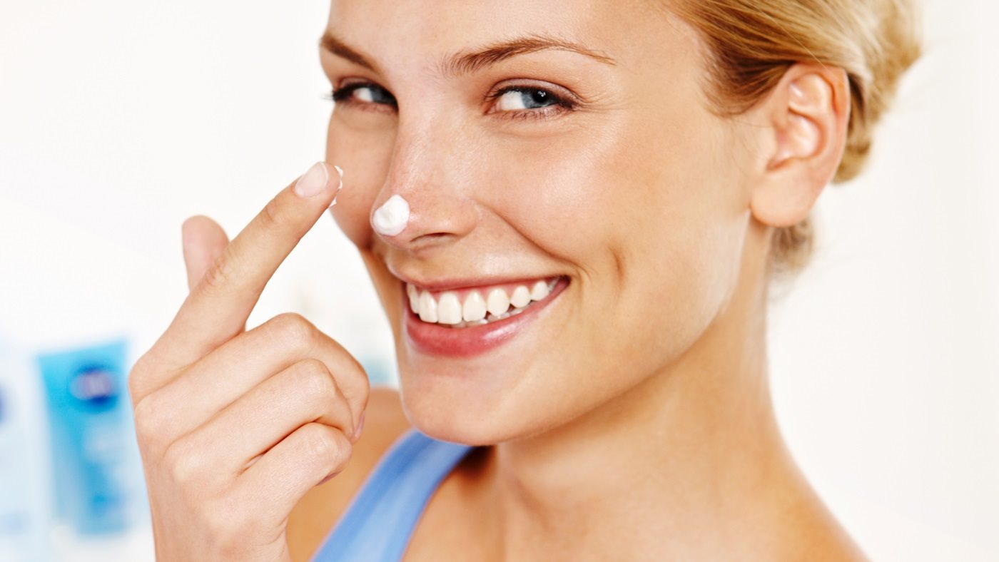 Frau die sich eincremt